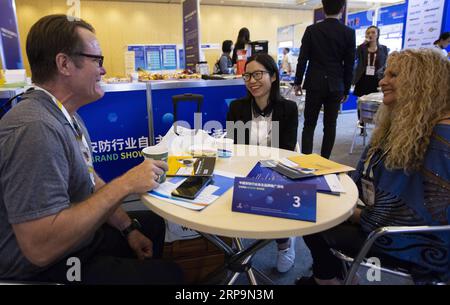 (190412) -- LAS VEGAS, 12 avril 2019 (Xinhua) -- Neytiri Qiu (C), représentant de Shenzhen Zhongxi Security Co. Ltd, parle avec les acheteurs à l'International Security Conference and Exposition (ISC West) de Las Vegas, aux États-Unis, le 10 avril 2019. Les sociétés de sécurité chinoises sont à la recherche de plus d'opportunités commerciales sur le marché américain à la Conférence et Exposition internationale de sécurité ici. Un total de 154 entreprises chinoises, à partir de secteurs, y compris la surveillance, les maisons intelligentes, contrôle d'accès et la sécurité à la frontière, participent au salon annuel du mercredi au vendredi, th Banque D'Images