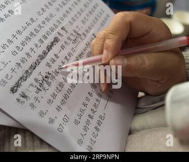 (190413) -- TONGLU, 13 avril 2019 (Xinhua) -- Wu Suhuan modifie son scénario pour raconter le film Kekexili : patrouille de montagne pour les personnes malvoyantes dans la branche de Tonglu de la bibliothèque braille de Chine dans le comté de Tonglu, province du Zhejiang, dans l'est de la Chine, 11 avril 2019. Wu Suhuan, 65 ans, est un patient atteint d'atrophie musculaire progressive et est paralysé depuis des décennies. Dédiée à travailler comme narratrice pour des films sans barrières, elle a jusqu'à présent écrit des scripts pour quatre films et les a lus avec le film pour les malvoyants depuis 2015. Je me sens heureux et satisfait de les aider, dit Wu. (Xinhua/Weng Banque D'Images