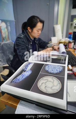 (190413) -- JINGDEZHEN, 13 avril 2019 (Xinhua) -- Une femme travaille à la restauration de porcelaine à Jingdezhen, dans la province du Jiangxi de l'est de la Chine, le 12 avril 2019. En préparation de l'exposition de porcelaine de Jingdezhen du milieu du 15e siècle de la dynastie Ming qui se tiendra à Shanghai en juin, des techniciens travaillent à la restauration de fragments de porcelaine découverts dans des fours royaux. Au total, 170 pièces de porcelaine fine provenant de fours royaux rencontreront le public dans l’exposition. (Xinhua/Zhou mi) CHINE-JIANGXI-JINGDEZHEN-PORCELAINE RESTAURATION (CN) PUBLICATIONxNOTxINxCHN Banque D'Images