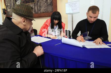 (190421) -- KIEV, le 21 avril 2019 -- des membres du personnel vérifient les renseignements d'un électeur dans un bureau de vote à Kiev, Ukraine, le 21 avril 2019. Les Ukrainiens ont commencé à voter dimanche lors d un deuxième tour de l élection présidentielle entre l acteur Volodymyr Zelensky et le président sortant Petro Porochenko. Chen Junfeng) UKRAINE-KIEV-ÉLECTION PRÉSIDENTIELLE-2E TOUR chenjunfeng PUBLICATIONxNOTxINxCHN Banque D'Images