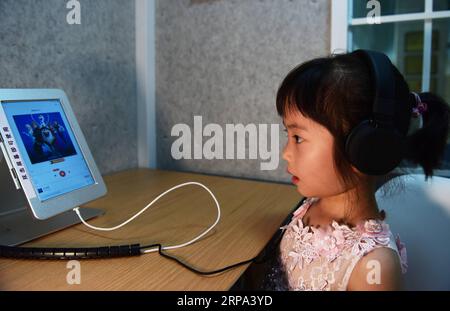 (190424) -- CHONGQING, 24 avril 2019 (Xinhua) -- Une fille écoute des livres audio dans un pavillon de lecture dans le district de Nan an, dans la municipalité de Chongqing au sud-ouest de la Chine, le 23 avril 2019. Les lecteurs peuvent lire à haute voix, enregistrer leur son et écouter des livres audio dans les pavillons de lecture. (Xinhua/Wang Quanchao) CHINA-CHONGQING-READING (CN) PUBLICATIONxNOTxINxCHN Banque D'Images