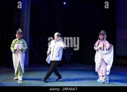 (190429) -- URUMQI, 29 avril 2019 (Xinhua) -- l'actrice He Nina (G) répète avec son collègue (D) suivant les conseils de leur réalisateur Ma Qi à Urumqi, capitale de la région autonome ouïgoure du Xinjiang du nord-ouest de la Chine, le 24 avril 2019. Née dans une famille dédiée à l'opéra Qinqiang, un opéra folklorique chinois du nord-ouest de la Chine, l'actrice He Nina, âgée de 33 ans, a joué le rôle d'une jeune femme dans l'opéra d'une troupe d'opéra Qinqiang à Urumqi depuis 2005. Au-delà des théâtres, He Nina et ses collègues ont joué l'opéra dans les communautés et les écoles pour promouvoir la culture traditionnelle de l'opéra chinois. Classe de performance Banque D'Images