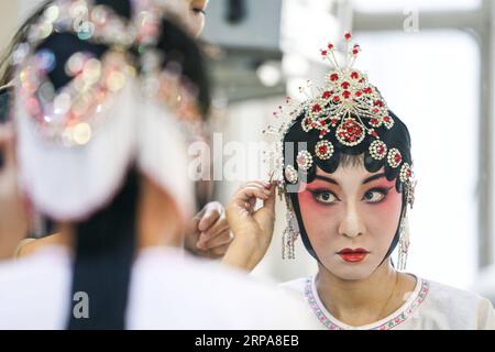 (190429) -- URUMQI, 29 avril 2019 (Xinhua) -- l'actrice He Nina arrange des coiffures avant de se produire à Urumqi, capitale de la région autonome ouïgoure du Xinjiang du nord-ouest de la Chine, le 24 avril 2019. Née dans une famille dédiée à l'opéra Qinqiang, un opéra folklorique chinois du nord-ouest de la Chine, l'actrice He Nina, âgée de 33 ans, a joué le rôle d'une jeune femme dans l'opéra d'une troupe d'opéra Qinqiang à Urumqi depuis 2005. Au-delà des théâtres, He Nina et ses collègues ont joué l'opéra dans les communautés et les écoles pour promouvoir la culture traditionnelle de l'opéra chinois. L'exécution d'œuvres classiques de l'opéra de Qinqiang devrait être adaptée Banque D'Images