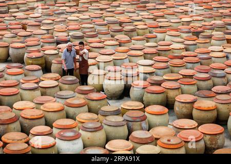 (190430) -- PÉKIN, 30 avril 2019 (Xinhua) -- Wu Huaqing et son grand-père Wu Zongzhong patrouillent parmi des pots de sauce soja dans sa compagnie à Quanzhou, dans la province du Fujian du sud-est de la Chine, le 29 avril 2019. (Xinhua/Lai Jincai) PHOTOS XINHUA DU JOUR PUBLICATIONxNOTxINxCHN Banque D'Images