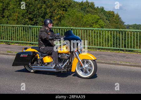 2005 jaune Harley-Davidson Flstfi Fatboy Fuel Injected V Twin Yellow Motorcycle essence Cruiser 1450 cc, V-Twin softail Cruiser moto avec roues à disque massif. Version du 15e anniversaire avec un moteur « Screamin' Eagle », une peinture spéciale et des roues personnalisées ; voyageant à grande vitesse sur l'autoroute M6 dans le Grand Manchester, Royaume-Uni Banque D'Images