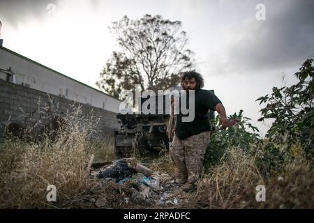 (190505) -- TRIPOLI, le 5 mai 2019 -- des combattants des forces du Gouvernement d'entente nationale (GNA) soutenu par l'ONU transfèrent des équipements d'un char détruit au Sud de Tripoli, en Libye, le 4 mai 2019. Au total, 392 personnes ont été tuées et 1 936 autres blessées dans les combats entre le gouvernement libyen soutenu par l'ONU et l'armée basée à l'est dans et autour de la capitale Tripoli, a déclaré jeudi l'Organisation mondiale de la santé (OMS). LIBYE-TRIPOLI-CONFLIT AmruxSalahuddien PUBLICATIONxNOTxINxCHN Banque D'Images