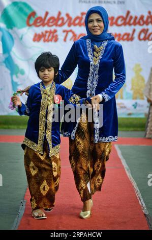 (190511) -- YOGYAKARTA, le 11 mai 2019 -- Une fille handicapée et sa mère participent au défilé de mode batik javanais pour enfants handicapés à Yogyakarta, Indonésie, le 11 mai 2019. Le spectacle pour les enfants handicapés a été organisé pour accroître leur confiance et aussi améliorer leur créativité dans la mode. INDONÉSIE-YOGYAKARTA-DÉFILÉ DE MODE-ENFANTS HANDICAPÉS SUPRIYANTO PUBLICATIONXNOTXINXCHN Banque D'Images