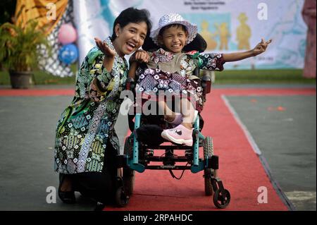 (190511) -- YOGYAKARTA, le 11 mai 2019 -- Une fille handicapée et sa mère participent au défilé de mode batik javanais pour enfants handicapés à Yogyakarta, Indonésie, le 11 mai 2019. Le spectacle pour les enfants handicapés a été organisé pour accroître leur confiance et aussi améliorer leur créativité dans la mode. INDONÉSIE-YOGYAKARTA-DÉFILÉ DE MODE-ENFANTS HANDICAPÉS SUPRIYANTO PUBLICATIONXNOTXINXCHN Banque D'Images