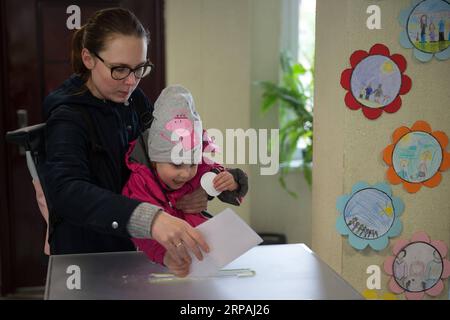 (190512) -- VILNIUS, le 12 mai 2019 -- Une enfant vote pour sa mère dans un bureau de vote de Vilnius, en Lituanie, le 12 mai 2019. L élection présidentielle et les deux référendums ont débuté dimanche en Lituanie avec neuf candidats en lice pour le poste le plus élevé du pays, dont le Premier ministre sortant Saulius Skvernelis. LITUANIE-VILNIUS-ÉLECTION PRÉSIDENTIELLE-RÉFÉRENDUMS AlfredasxPliadis PUBLICATIONxNOTxINxCHN Banque D'Images