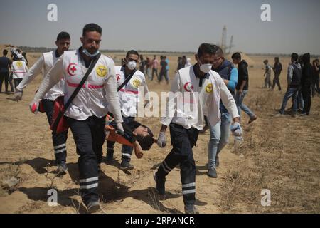 (190515) -- GAZA, 15 mai 2019 -- des médecins palestiniens transportent un blessé lors d'affrontements avec les troupes israéliennes à la frontière Gaza-Israël, à l'est de la ville de Khan Younis, dans le sud de la bande de Gaza, le 15 mai 2019. Au moins 65 Palestiniens ont été blessés mercredi lors d'affrontements avec des soldats israéliens stationnés à la frontière entre l'est de la bande de Gaza et Israël, ont déclaré les médecins. MIDEAST-GAZA-AFFRONTEMENTS KhaledxOmar PUBLICATIONxNOTxINxCHN Banque D'Images