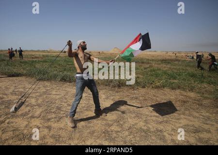(190515) -- GAZA, 15 mai 2019 -- Un manifestant palestinien utilise une fronde pour lancer des pierres sur les troupes israéliennes lors d'affrontements à la frontière Gaza-Israël, à l'est de la ville de Khan Younis, dans le sud de la bande de Gaza, le 15 mai 2019. Au moins 65 Palestiniens ont été blessés mercredi lors d'affrontements avec des soldats israéliens stationnés à la frontière entre l'est de la bande de Gaza et Israël, ont déclaré les médecins. MIDEAST-GAZA-AFFRONTEMENTS KhaledxOmar PUBLICATIONxNOTxINxCHN Banque D'Images