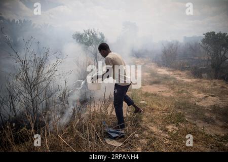 (190515) -- TRIPOLI, le 15 mai 2019 -- Un homme éteint un incendie provoqué par un obus de mortier lors d'affrontements entre les forces gouvernementales soutenues par l'ONU et les troupes de l'Armée nationale libyenne (ANL) sur la ligne de front Al-Sawani près de l'aéroport de Tripoli à Tripoli, Libye, le 15 mai 2019. Le gouvernement libyen soutenu par l'ONU a salué mercredi l'appel de l'Union européenne (UE) en faveur d'un cessez-le-feu à Tripoli, qui est témoin de violents affrontements entre le gouvernement et l'armée basée à l'est pour le contrôle de la ville. LIBYE-TRIPOLI-CONFLIT AmruxSalahuddien PUBLICATIONxNOTxINxCHN Banque D'Images