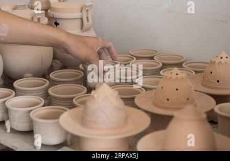 (190520) -- LONGQUAN, 20 mai 2019 (Xinhua) -- Lin Song vérifie les bases d'argile pour les brûleurs d'encens céladon dans son atelier de Longquan, province du Zhejiang dans l'est de la Chine, 20 mai 2019. Né en 1993, Lin Song est originaire de Longquan, qui abrite les meilleures marchandises de céladon en Chine. Il a reçu une formation professionnelle à la fois dans sa ville natale et à Jingdezhen, un autre centre important de porcelaine de Chine. Lin avait également suivi d'autres artisans céladons pendant des années avant d'installer un studio chez lui en 2014, se concentrant sur la réplication des brûleurs d'encens céladons classiques. La collection personnelle de LIN s est développée à plus de 40 incens céladon Banque D'Images