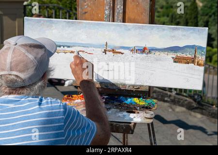 Un artiste florentin, peinture à l'huile d'une scène d'horizon de Florence de Piazzale Michelangelo dans la région toscane en Italie. Banque D'Images