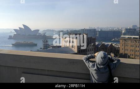 (190524) -- SYDNEY, le 24 mai 2019 -- Un touriste prend des photos à Sydney, Australie, le 24 mai 2019. La brume de fumée qui a étouffé Sydney plus tôt dans la semaine est revenue, enveloppant à nouveau la ville dans un épais brouillard, même si le service des incendies ruraux de Nouvelle-Galles du Sud a arrêté mercredi la réduction des risques de brûlure en raison de la mauvaise qualité de l'air.) AUSTRALIE-SYDNEY-SMOG BaixXuefei PUBLICATIONxNOTxINxCHN Banque D'Images