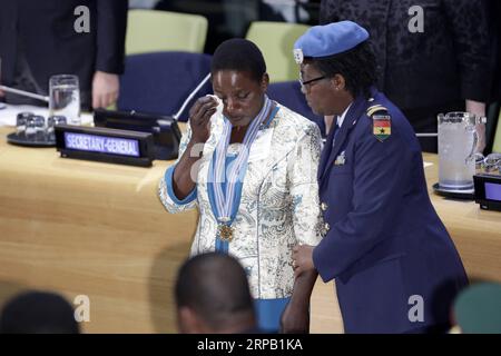 (190524) -- NATIONS UNIES, 24 mai 2019 -- Chitete Mwenechanya (G), qui porte autour du cou la médaille décernée à son défunt mari, essuie ses larmes lors d'une cérémonie au siège de l'ONU à New York, le 24 mai 2019. Un soldat malawien, qui a donné sa vie pour sauver un camarade d'armes dans une opération de l'ONU en République démocratique du Congo (RDC) en novembre 2018, a reçu vendredi, à titre posthume, la plus haute et la plus prestigieuse reconnaissance pour le maintien de la paix de l'ONU. La médaille Capitaine Mbaye Diagne pour courage exceptionnel a été décernée au soldat Chancy Chitete. Sa famille a reçu la médaille en son nom f Banque D'Images