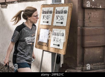 (190526) -- STRASBOURG, le 26 mai 2019 -- Une femme passe devant des pancartes pour se rendre au bureau de vote de Strasbourg, France, le 26 mai 2019. Les élections au Parlement européen (UE) ont débuté dimanche en France. ) FRANCE-STRASBOURG-PARLEMENT EUROPÉEN-ELECTION MartinxLelievre PUBLICATIONxNOTxINxCHN Banque D'Images