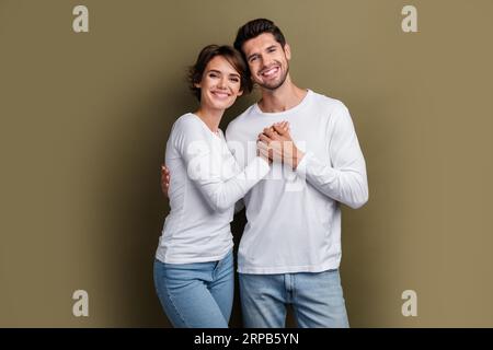 Photo de couple positif doux embrassant porter des vêtements blancs Profitez du temps ensemble anniversaire lune de miel isolé sur fond de couleur marron Banque D'Images