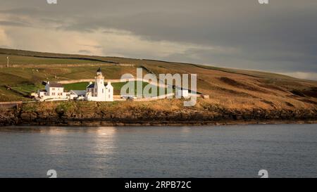 Scrabster, Thurso, Écosse, Royaume-Uni - 11 avril 2023 : une vue du phare de Holborn Head prise du ferry Scrabster à Stromness au lever du soleil. Banque D'Images
