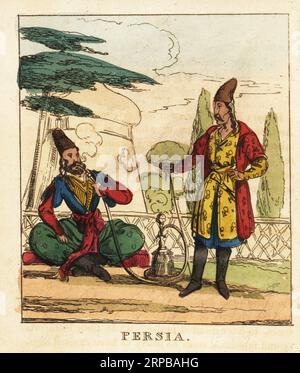 Costumes de Perse, 19e siècle. Un homme barbu est assis sur un divan fumant une pipe de narguilé. Un autre homme à fès, manteau, robe et bottes avec un poignard. Gravure sur cuivre colorée à la main du monde en miniature, ou Panorama des costumes, Manners & Customs of All Nations, John Bysh, Londres, 1825. Banque D'Images