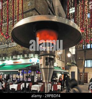 Fermer l'élément chauffant du chauffage extérieur Calor Gas à côté des tables de restaurant à Noël à St Christophers place West End Londres Angleterre Royaume-Uni Banque D'Images