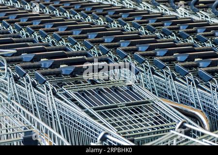 Chariots de chariot empilés devant le magasin de supermarché, concept de panier de marchandises, focalisation sélective Banque D'Images