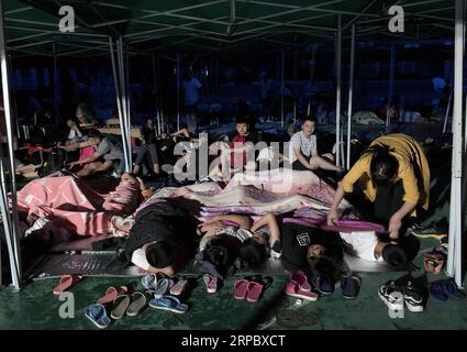 (190618) -- CHANGNING, 18 juin 2019 (Xinhua) -- Un enseignant met des élèves dans leur lit sous une tente dans la cour de récréation du lycée de Shuanghe Town, dans le comté de Changning, dans la ville de Yibin, dans le sud-ouest de la Chine, province du Sichuan, 18 juin 2019. Onze personnes sont mortes et 122 autres ont été blessées après un tremblement de terre de magnitude 6,0 qui a frappé le comté de Changning lundi soir, a déclaré le gouvernement de la ville de Yibin tôt mardi. (Xinhua/Zeng Lang) CHINE-SICHUAN-CHANGNING-TREMBLEMENT DE TERRE (CN) PUBLICATIONxNOTxINxCHN Banque D'Images