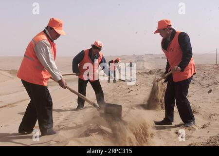 (190622) -- YINCHUAN, 22 juin 2019 (Xinhua) -- une photo prise en avril 2002 montre des travailleurs dégageant une route recouverte de sable dans le canton de Jianerzhuang, dans le comté de Yanchi, dans le nord-ouest de la Chine, dans la région autonome hui de Ningxia. Situé à la lisière sud du désert de Maowusu, le comté de Yanchi était autrefois frappé par la pauvreté et a souffert de la désertification. Mais après des années d'efforts, l'environnement a été restauré, et le comté a également ébranlé la pauvreté. (Xinhua/Liu Quanlong) CHINA-NINGXIA-YANCHI-POVERTY ELIMINATION (CN) PUBLICATIONxNOTxINxCHN Banque D'Images