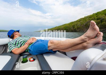 Un homme se détendant dans la proue de bateau à moteur à Skaneateles Lake, New York, USA Banque D'Images