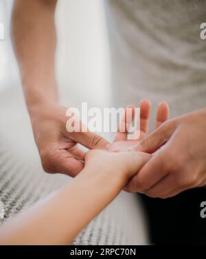 Massothérapeute appliquant une pression sur la main d'un patient Banque D'Images