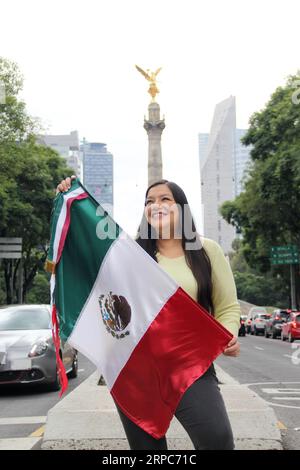 Femme adulte latine montre le drapeau du mexique fière de la culture et de la tradition de son pays, célèbre le patriotisme mexicain Banque D'Images