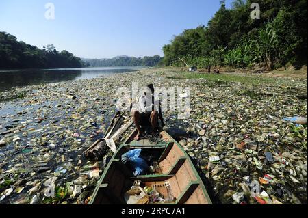 (190626) -- BANDUNG, le 26 juin 2019 -- un homme rame un bateau sur la rivière Citarum qui est recouverte de déchets plastiques à Bandung, Java Ouest, Indonésie, le 26 juin 2019. h) INDONÉSIE-BANDUNG-DÉCHETS PLASTIQUES BukbisxChandraxIsmet PUBLICATIONxNOTxINxCHN Banque D'Images