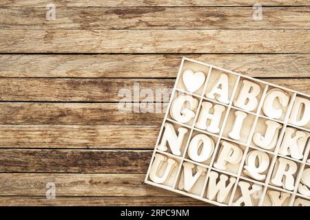 Un ensemble de lettres en bois dans une boîte en bois, vue de dessus. Banque D'Images