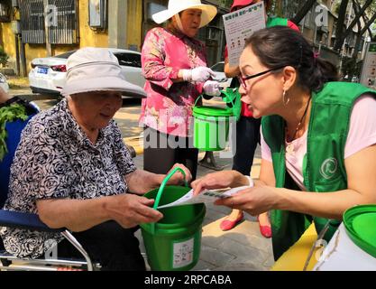 (190629) -- BEIJING, 29 juin 2019 -- des volontaires expliquent aux résidents locaux comment utiliser les transporteurs de déchets de cuisine à Beijing, capitale de la Chine, le 29 juin 2019. Vendredi, la Chine a promis des efforts considérables pour promouvoir le tri des ordures ménagères à l'échelle nationale. Le pays investira 21,3 milliards de yuans (3,1 milliards de dollars américains) dans la construction d'installations de traitement des ordures pour répondre à la demande, a déclaré Zhang Lequn, un fonctionnaire du ministère du logement et du développement urbain-rural, lors d'une conférence de presse. CHINE-PÉKIN-TRI-PROMOTION DES ORDURES MÉNAGÈRES (CN) LIXXIN PUBLICATIONXNOTXINXCHN Banque D'Images