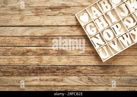 Un ensemble de lettres en bois dans une boîte en bois, vue de dessus. Banque D'Images