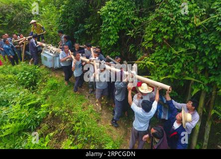 (190704) -- RONGSHUI, 4 juillet 2019 -- sur cette photo aérienne prise le 25 avril 2019, des responsables de la lutte contre la pauvreté et des villageois sont vus en train de remplacer un transformateur de tension dans le village de Dangjiu, dans le comté autonome de Rongshui Miao, Liuzhou, dans la région autonome de Guangxi Zhuang, dans le sud de la Chine. La médiocrité des infrastructures de transport sur un terrain principalement montagneux a laissé le comté de Rongshui hanté par une pauvreté extrême. Pendant des années, résoudre les problèmes de pauvreté de Rongshui reste une priorité pour les responsables de la lutte contre la pauvreté. Dans le cadre d'une récente campagne, le département municipal de l'organisation du Parti de Li Banque D'Images