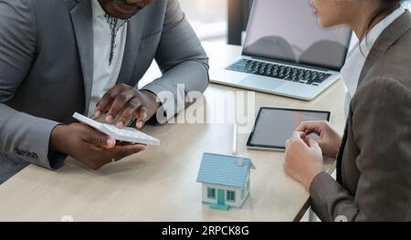 Femme d'affaires asiatique a une réunion avec un agent immobilier afro-américain au sujet de l'assurance habitation et prêt d'investissement Banque D'Images