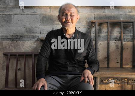 (190708) -- RUCHENG, 8 juillet 2019 -- Zhu Zhongxiong, 81 ans, fils de Xu Jiexiu, pose pour une photo au village de Shazhou dans le comté de Rucheng, province du Hunan, au centre de la Chine, le 14 juin 2019. Des dizaines de milliers de personnes de tout le pays sont venues la semaine dernière dans un petit village de la province du Hunan, au centre de la Chine, à la recherche d'une courtepointe, pour être exact, une courtepointe réduite de moitié qui n'est maintenant plus en mesure d'être trouvée. La courtepointe coupée en deux a été coupée par trois jeunes femmes soldats de l'Armée Rouge en cadeau à Xu Jiexiu, une femme de campagne qui vivait dans le village de Shazhou avec son mari et son fils d'un an en 1934. Cinquante ans plus tard, un JO chinois Banque D'Images