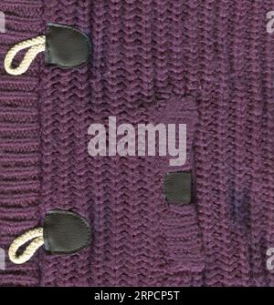 Tissu cardigan à motifs en laine. Texture de fond de pull en laine violette en tissu tricoté à la main Banque D'Images