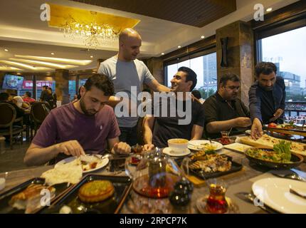 (190710) -- YIWU, 10 juillet 2019 -- Aziz (3e L) discute avec son ami, un propriétaire de restaurant jordanien, dans la ville de Yiwu, province de Zhejiang de l'est de la Chine, 9 juillet 2019. Aziz Ullah, 41 ans, est venu à la ville de Yiwu dans la province du Zhejiang de l est de la Chine en 2003 avec ses partenaires après son diplôme de l université dans son pays d origine, l Afghanistan. C'était sa première fois de venir à Yiwu pour magasiner pour la petite vaisselle. En 2005, Aziz a créé sa propre entreprise après avoir été agent pendant environ 2 ans. Au cours des dernières années, l initiative Belt and Road a apporté des opportunités formidables à l entreprise d Aziz. Il a acheté plus de 200 conteneurs Banque D'Images