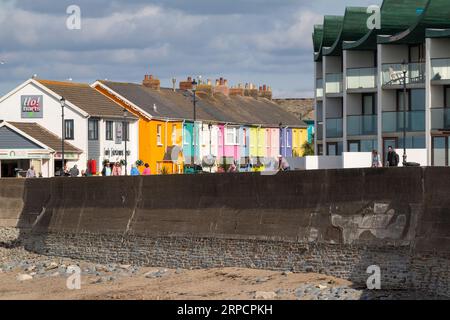 Détail du front de mer à Westward Ho! Avec des maisons colorées, appartements modernes et mur de mer avec des gens. Banque D'Images