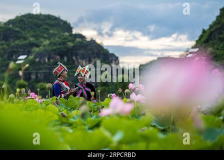 (190712) -- QIUBEI, 12 juillet 2019 -- des visiteurs du groupe ethnique Zhuang voient des fleurs de lotus dans le parc national des zones humides de Puzhehei, dans le comté de Qiubei, dans le sud-ouest de la Chine, province du Yunnan, 11 juillet 2019.) CHINA-YUNNAN-QIUBEI-PUZHEHEHEI PARC NATIONAL DES ZONES HUMIDES (CN) JIANGXWENYAO PUBLICATIONXNOTXINXCHN Banque D'Images