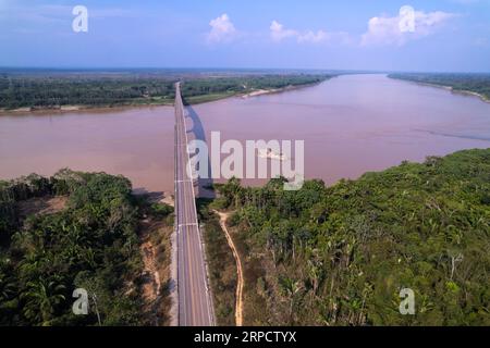 Magnifique paysage de forêt amazonienne vue aérienne du pont routier BR-364 sur la rivière Madère à la frontière du Brésil et de la Bolivie en journée ensoleillée d'été. Banque D'Images