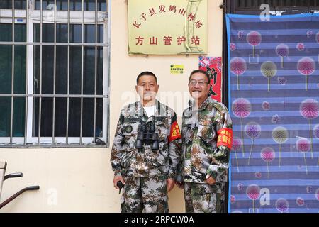 (190713) -- ZHANGZI, 13 juillet 2019 -- les gardes forestiers M. He Xiaohong(L) et Lin Zhongkui posent pour une photo à leur poste de patrouilleur forestier sur le mont Fajiu, à 25 km à l'ouest du comté de Zhangzi, province du Shanxi au nord de la Chine, le 12 juillet 2019. Il y a une station Forest-patroller sur le mont Fajiu où la couverture forestière représente près de 90 pour cent. M. He Xiaohong s'occupe de la protection des forêts depuis 34 ans depuis qu'il a 19 ans. Avec ses collègues de travail, M. He doit patrouiller deux fois du matin au soir toute l'année pour s'assurer que les forêts sont en bon état. Sous leur protectio Banque D'Images