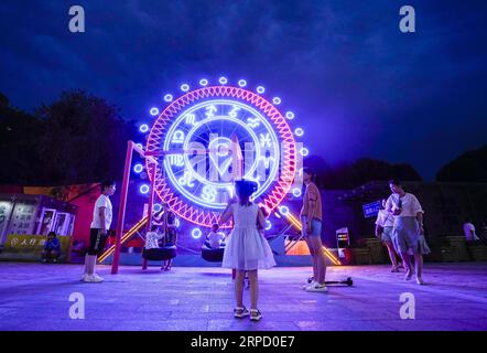 (190717) -- URUMQI, 17 juillet 2019 -- des enfants jouent près d'une installation illuminée à Urumqi, dans la région autonome ouïgoure du Xinjiang, au nord-ouest de la Chine, le 14 juillet 2019. L’économie nocturne a repris à Urumqi depuis juillet. Les gens s'amusent les nuits fraîches d'été en faisant du shopping et en dégustant de la nourriture.) CHINA-XINJIANG-URUMQI-NIGHT-ECONOMY (CN) ZHAOXGE PUBLICATIONXNOTXINXCHN Banque D'Images