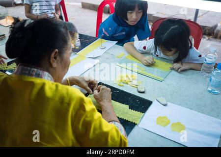 (190717) -- UBON RATCHATHANI (THAÏLANDE), 17 juillet 2019 -- des gens fabriquent des composants d'une bougie dans un temple à Ubon Ratchathani, Thaïlande, 15 juillet 2019. Le Festival des bougies Ubon Ratchathani est organisé pour commémorer le premier sermon de Bouddha et marquer le début du carême bouddhiste. Le point culminant de l'événement annuel est le défilé de chars géants de sculptures de cire dans toute la ville, chacun représentant un temple local, un quartier ou une institution. THAÏLANDE-UBON RATCHATHANI-BOUGIE FESTIVAL ZhangxKeren PUBLICATIONxNOTxINxCHN Banque D'Images