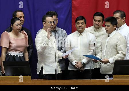 (190722) -- QUEZON CITY, le 22 juillet 2019 -- Alan Peter Cayetano (2e front L) est assermenté à titre de 22e président de la Chambre des représentants à Quezon City, Philippines, le 22 juillet 2019. La Chambre des représentants des Philippines a élu lundi Alan Peter Cayetano 22e Président de la Chambre à l'ouverture du 18e Congrès. Le Président philippin Rodrigo Duterte a précédemment approuvé la présidence de Cayetano. Cayetano, 48 ans, homme politique et allié de Duterte, a été co-candidat battu de Duterte aux élections de mai 2016. (Oliver Marquez/PNA photo via Xinhua) PHILIPPINES-QUEZON-HOU Banque D'Images