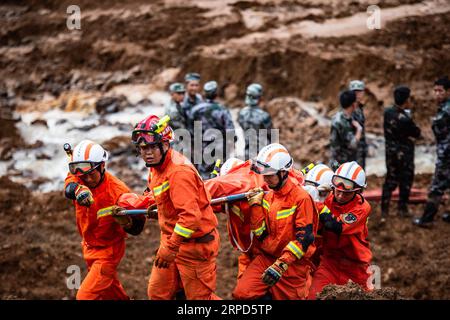 (190724) -- SHUICHENG, le 24 juillet 2019 -- des sauveteurs transfèrent le corps d'une victime sur un site de glissement de terrain dans le village de Pingdi, dans le comté de Shuicheng, dans la ville de Liupanshui, dans le sud-ouest de la Chine, dans la province du Guizhou, le 24 juillet 2019. Onze personnes sont mortes après un glissement de terrain qui a frappé le village de Pingdi mardi soir, ont déclaré mercredi les autorités locales. Vers 9:20 h (1320 h GMT) mardi, un glissement de terrain a frappé le village, enterrant 21 maisons. Plus de 50 personnes vivaient dans la zone touchée lorsque le glissement de terrain a frappé, selon les sauveteurs. Mercredi vers 11 heures (0300 heures GMT), 11 personnes ont été retrouvées mortes, 11 autres ont été secourues Banque D'Images