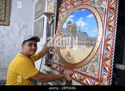 (190724) -- DAMAS, 24 juillet 2019 -- Un artisan syrien montre une peinture damasquinée dans un atelier établi dans une ancienne maison appelée la Maison d'Orient dans le quartier al-Midan de la capitale Damas le 11 juillet 2019. La Maison d'Orient a fourni des abris à plusieurs artisans qui se sont réunis en 2018 liés à l'amour de leurs professions paternelles pour faire revivre ces métiers et l'enseigner à la nouvelle génération. POUR ALLER AVEC la caractéristique : les artisans tentent de sauver les vieux métiers Damascène de l'extinction ) SYRIE-DAMAS-ARTISANAT AmmarxSafarjalani PUBLICATIONxNOTxINxCHN Banque D'Images