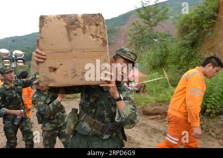 (190724) -- SHUICHENG, le 24 juillet 2019 -- des sauveteurs transfèrent des marchandises de secours en cas de catastrophe dans le comté de Shuicheng de la ville de Liupanshui, dans la province du Guizhou du sud-ouest de la Chine, le 24 juillet 2019. Le nombre de morts est passé à 13 après un glissement de terrain dans la province du Guizhou du sud-ouest de la Chine mardi, ont déclaré mercredi les autorités locales. Mercredi à 5:15 heures, 13 personnes avaient été retrouvées mortes, 11 autres ont été secourues, et environ 32 personnes étaient toujours portées disparues. Les travaux de sauvetage sont toujours en cours. ) CHINA-GUIZHOU-SHUICHENG-LANDSLIDE-RESCUE WORK (CN) YANGXYING PUBLICATIONXNOTXINXCHN Banque D'Images